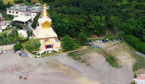 舍利塔與對面小神廟之間，尚未恢復綠色植被的土地，就是現今菩提心園。（2010年）